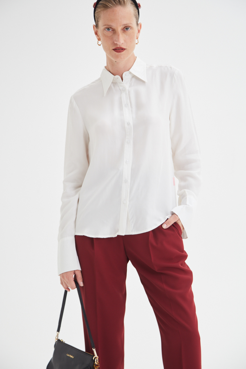 Camisa blanca de calce recto y puños anchos con textura suave de piel de durazno. 
