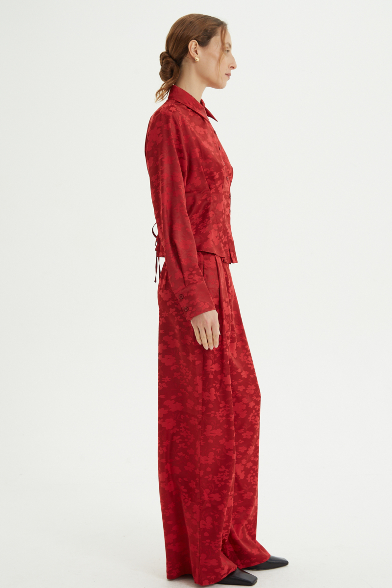 Camisa roja satinada de jacquard floreado con pinzas de entalle en frente y espalda, con lazo para regular. 