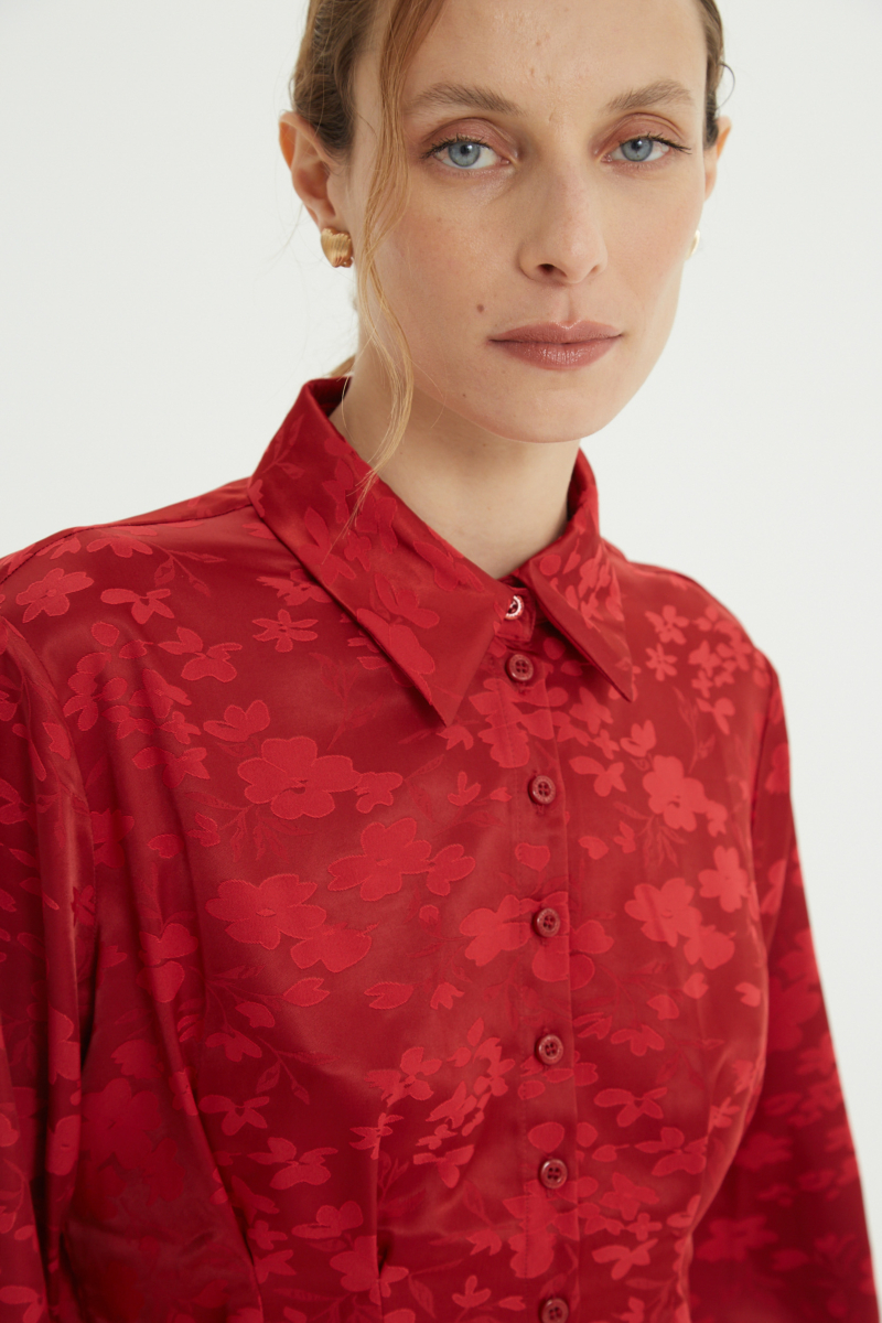 Camisa roja satinada de jacquard floreado con pinzas de entalle en frente y espalda, con lazo para regular. 