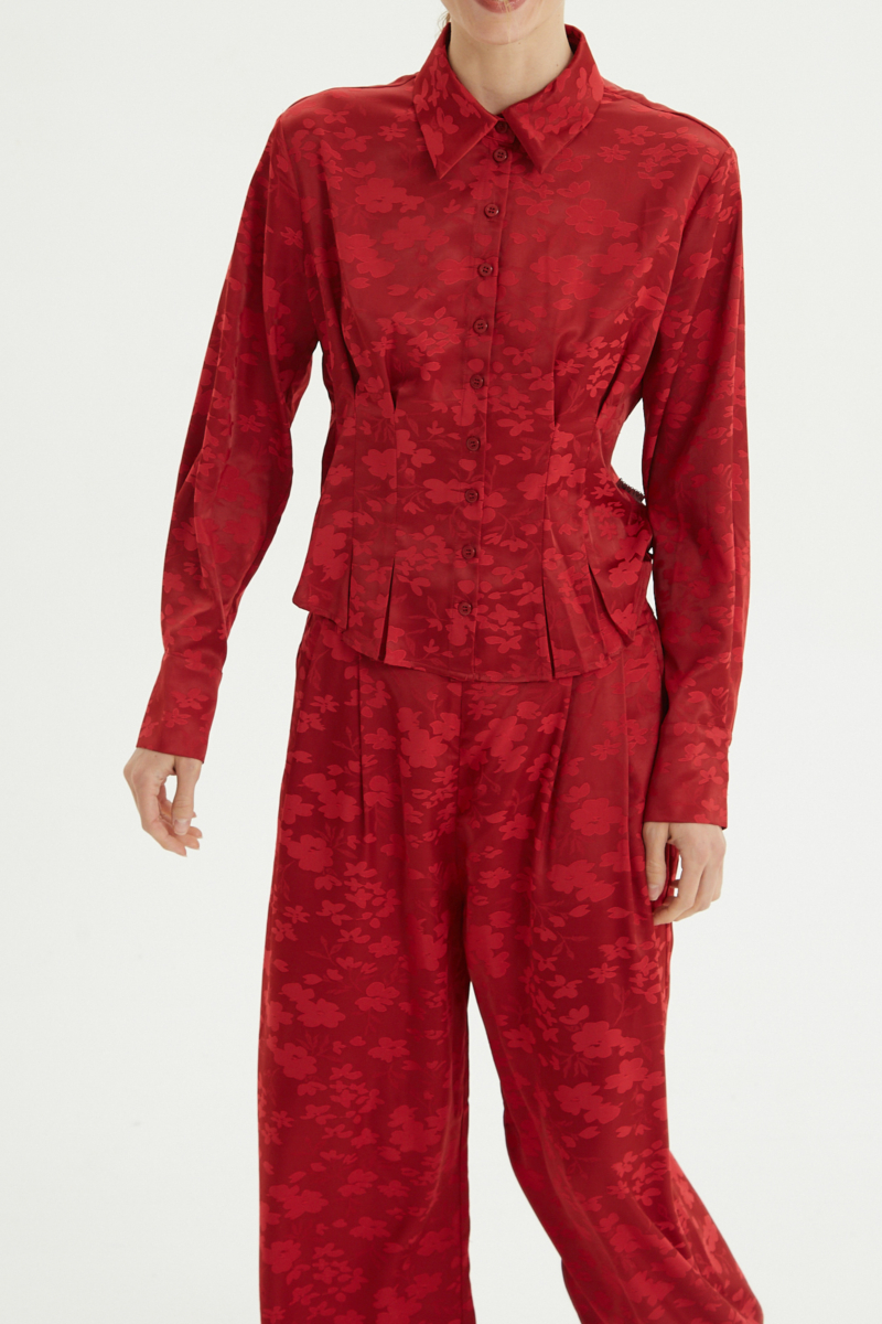 Camisa roja satinada de jacquard floreado con pinzas de entalle en frente y espalda, con lazo para regular. 