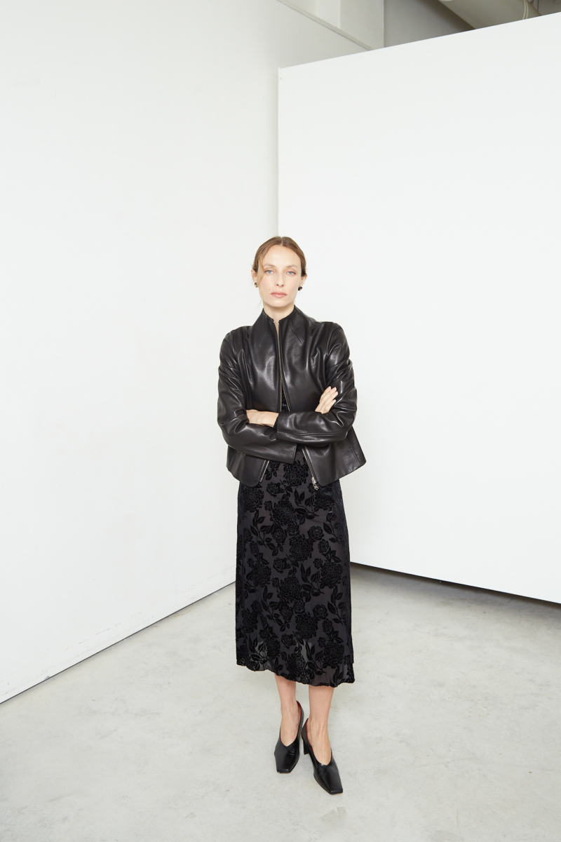Vestido negro largo y al cuerpo de microtul con textura de flores de terciopelo y cuello bote. 