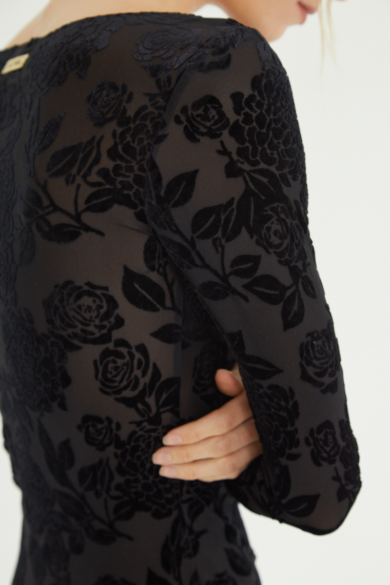 Vestido negro largo y al cuerpo de microtul con textura de flores de terciopelo y cuello bote. 