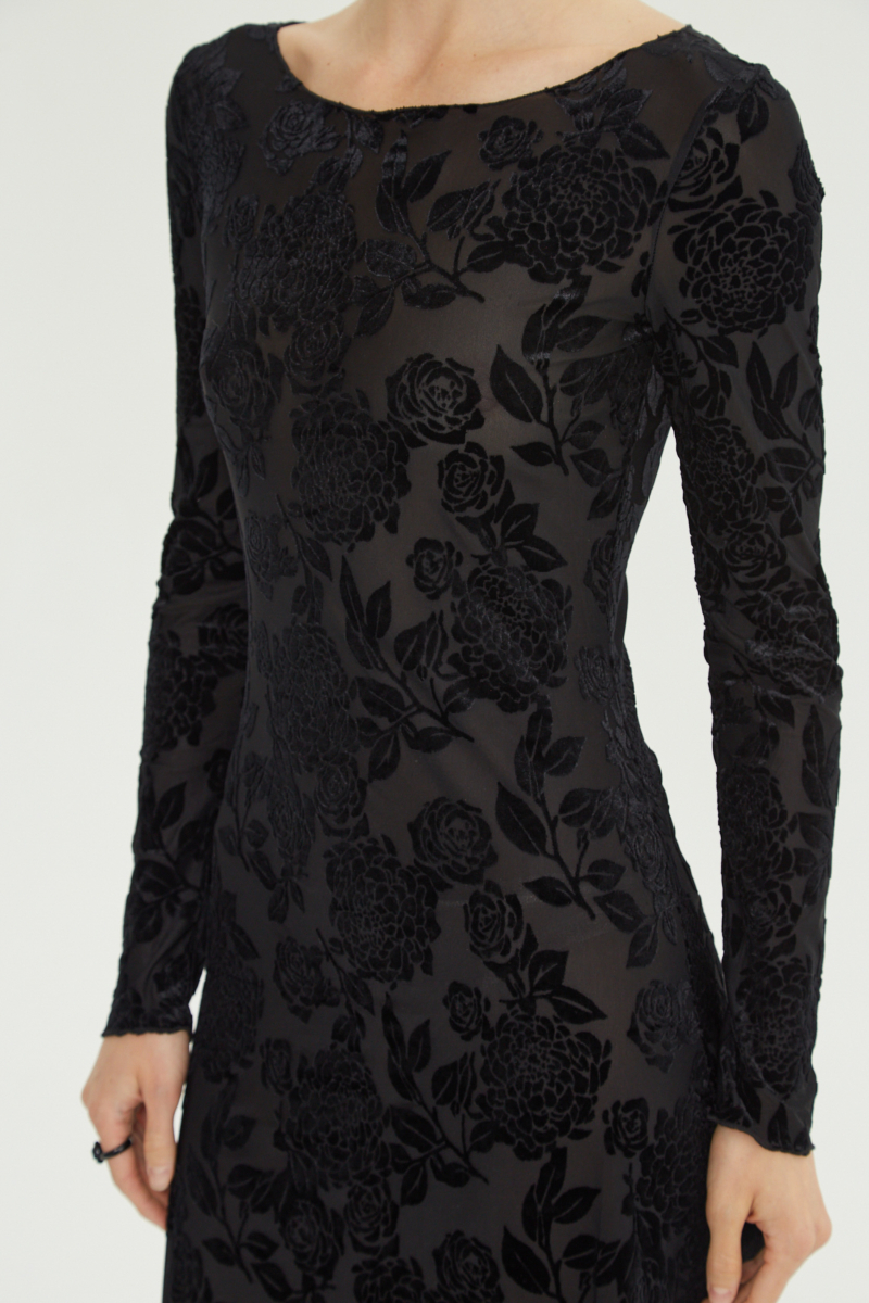 Vestido negro largo y al cuerpo de microtul con textura de flores de terciopelo y cuello bote. 