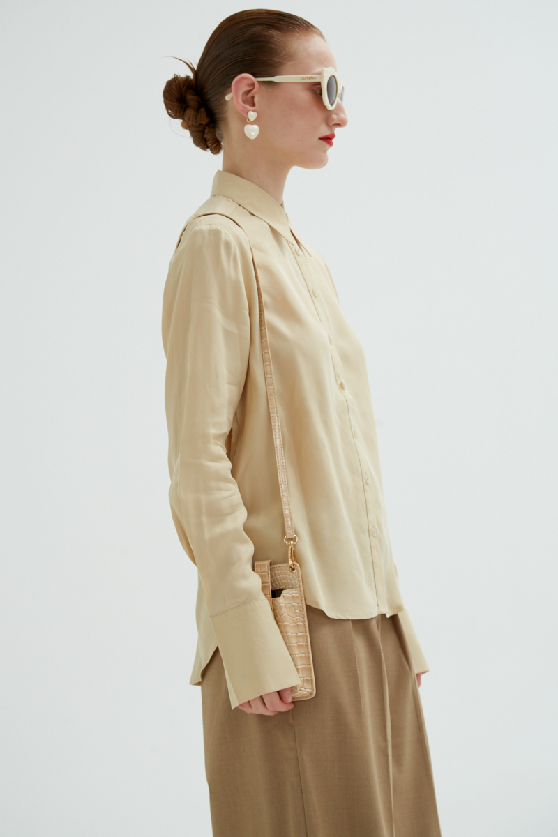 Camisa beige de calce recto y puños anchos con textura suave de piel de durazno. 
