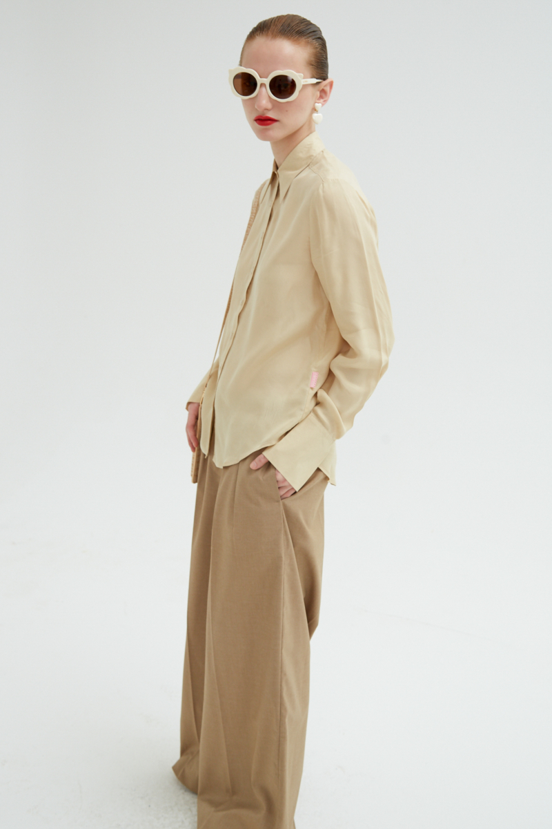 Camisa beige de calce recto y puños anchos con textura suave de piel de durazno. 
