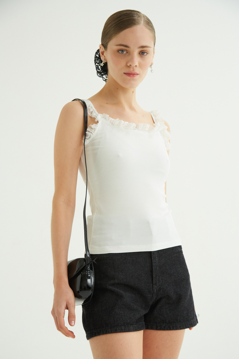 Musculosa negra de morley con breteles finos y cuello con volados de encaje.
