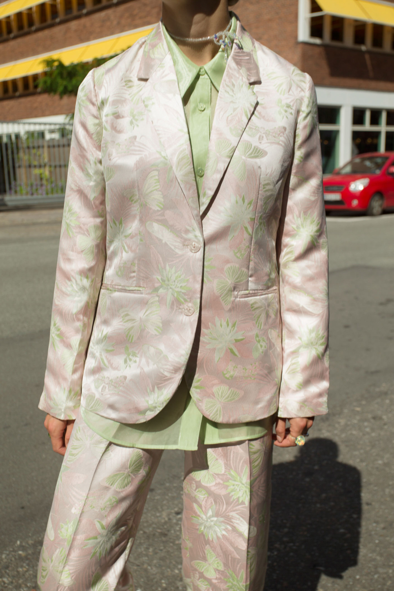 Saco rosa sastrero recto de jacquard satinado con hombreras, solapa con cruce recto y botones tornasolados. 

