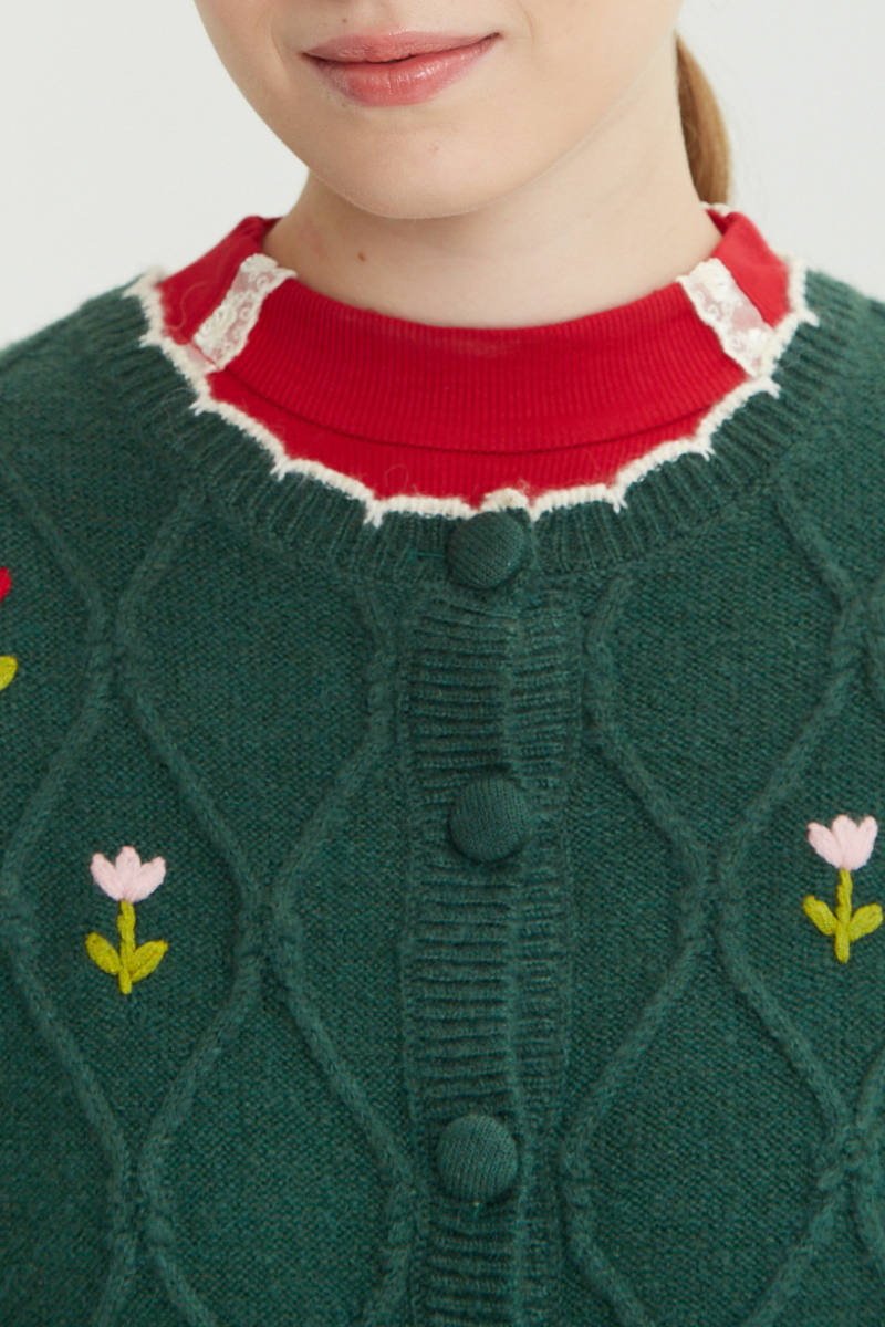 Cardigan tejido con patrón de rombos con flores bordadas y terminación en forma de onditas a contratono
