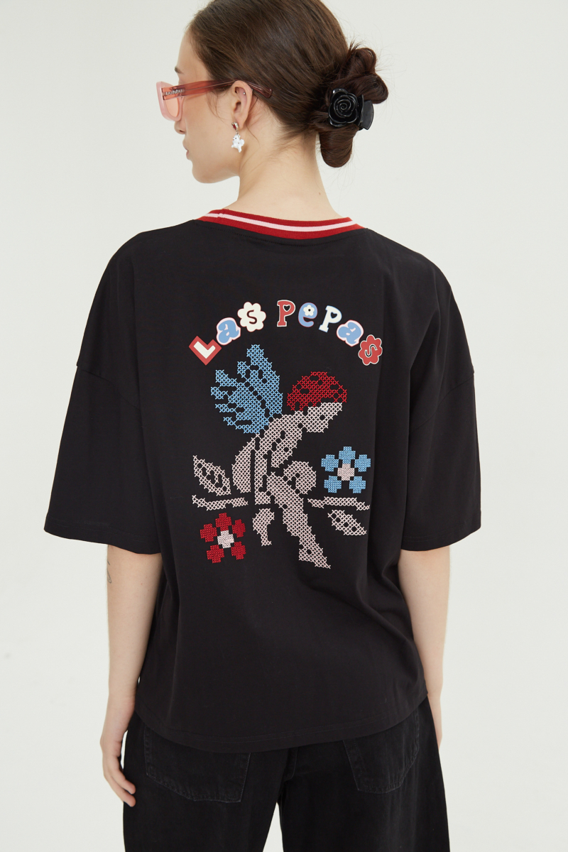 Remera oversize de algodón con bordado en punto cruz al frente y estampa en la espalda. 

