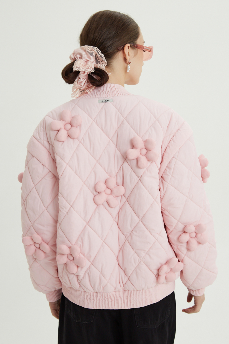 Campera matelaseada con apliques 3D de flores puffer, cuello y puños de ribb, cierre doble camino y mangas desmontables. 