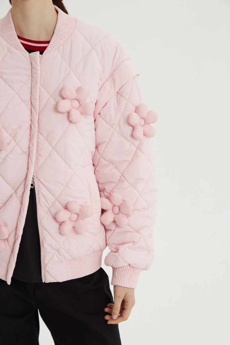 Campera matelaseada con apliques 3D de flores puffer, cuello y puños de ribb, cierre doble camino y mangas desmontables. 