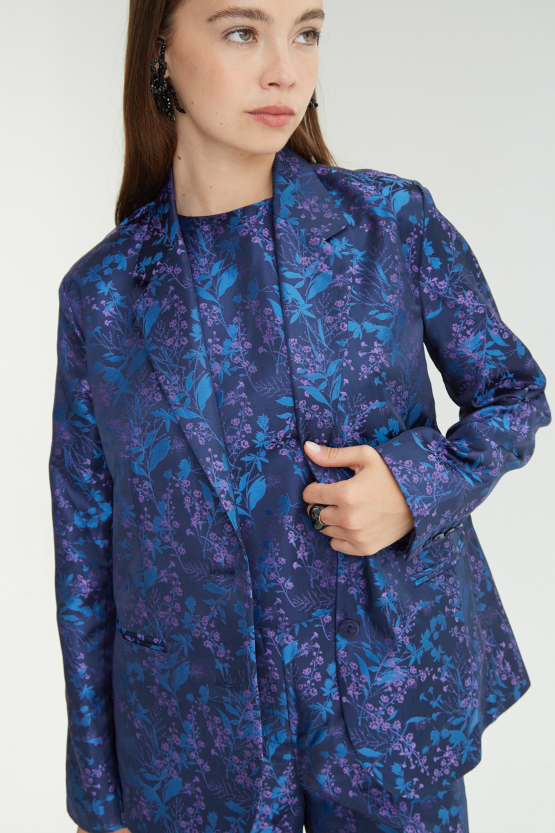 Saco azul sastrero recto de jacquard satinado con hombreras, solapa con cruce recto y botones tornasolados. 
