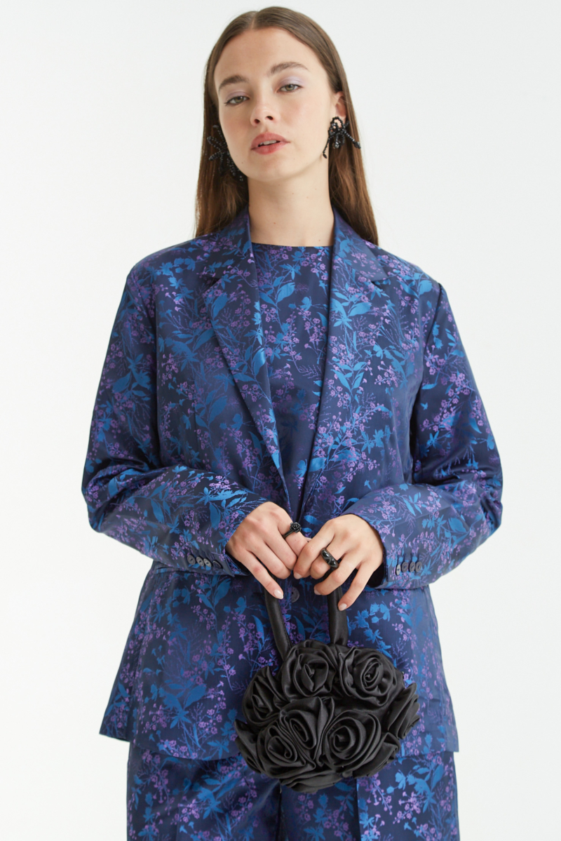 Saco azul sastrero recto de jacquard satinado con hombreras, solapa con cruce recto y botones tornasolados. 
