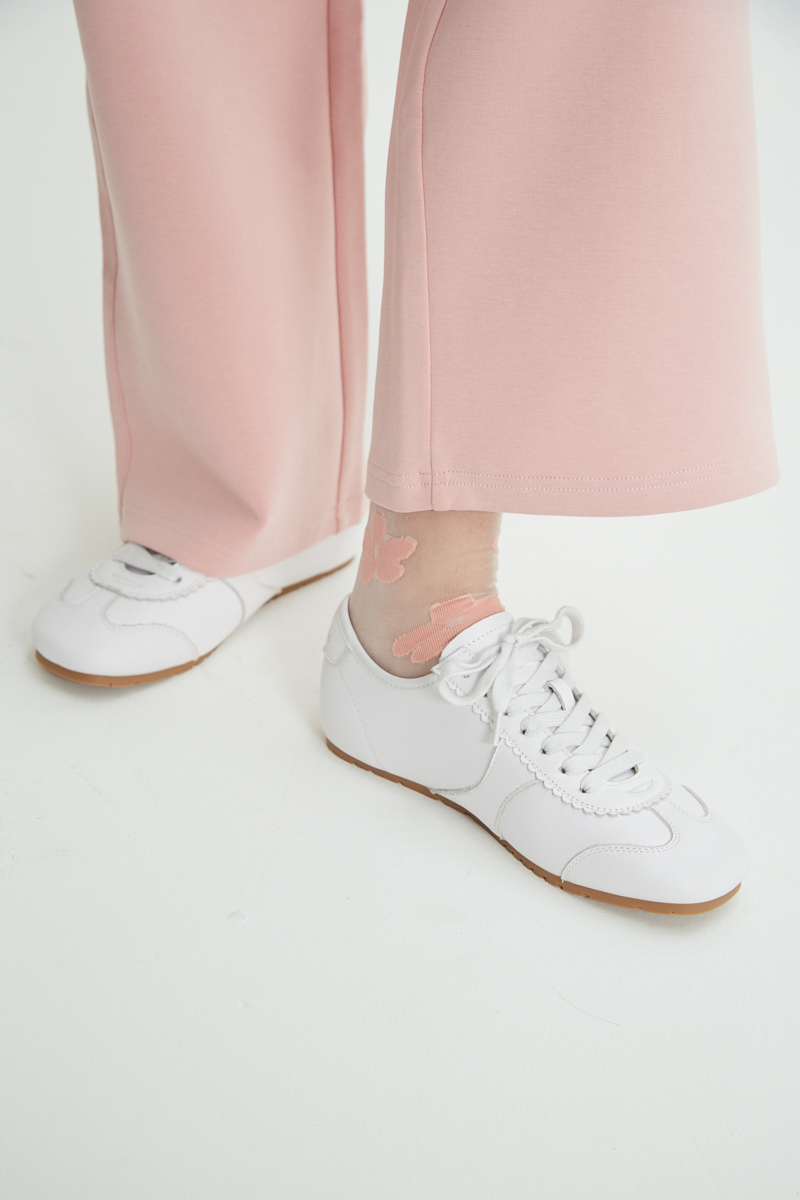 Zapatillas blancas de cuero con recortes, punta cuadrada y suela de caucho.
