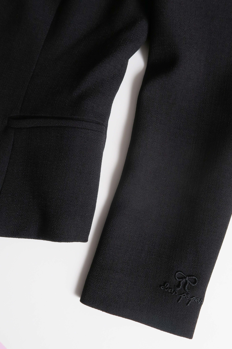 Blazer negro sastrero entallado con terminación ondulada y mangas princesa. 
