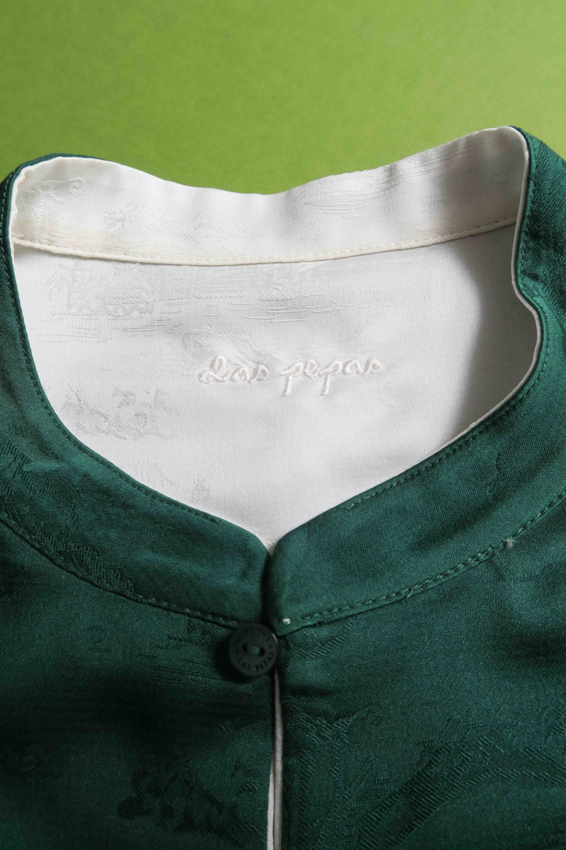 Blusa cruda reversible de jacquard satinado sin mangas con cuello mao, botones a tono, pinzas frontales y aberturas laterales.