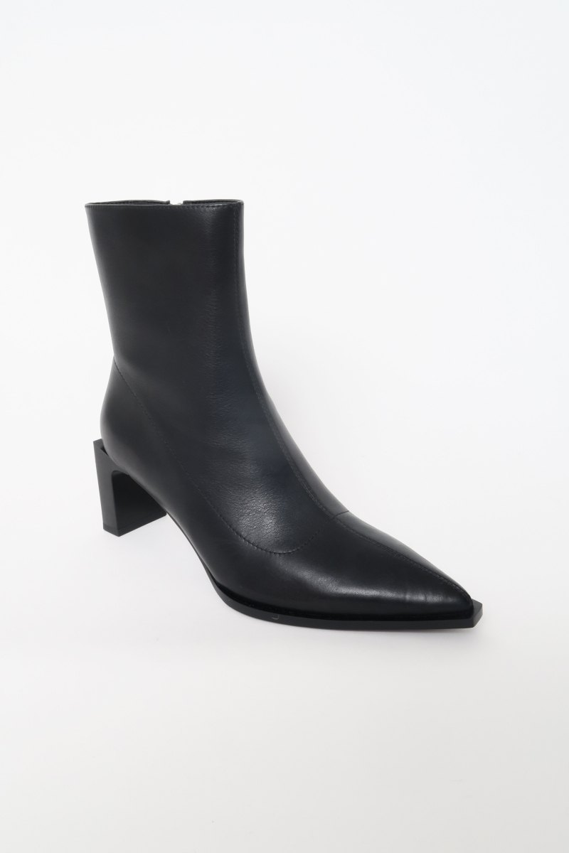 Botas de cuero de caña media en punta con taco rectangular de 7 cm y cierre lateral oculto. 
