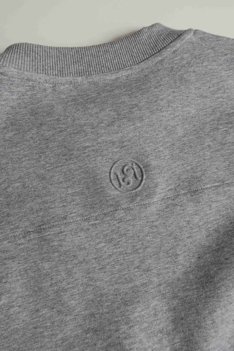 Buzo gris de algodón con mangas amplias, cuello redondo, hombros y sisas caídas. 
