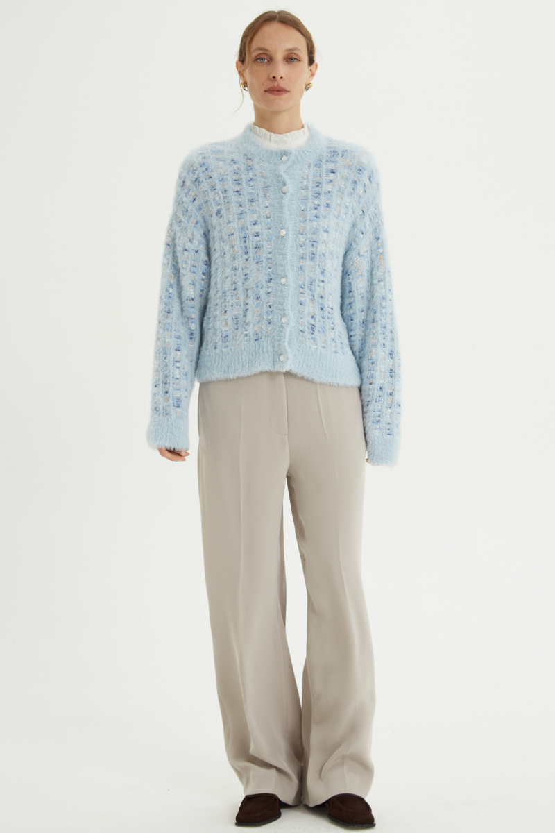 Saco tejido multicolor con textura de pelo y botones perlados en forma de flor. 
