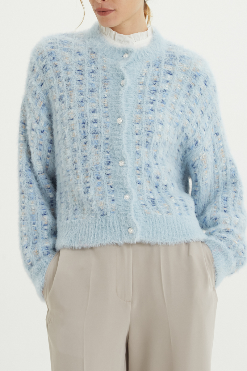 Saco tejido multicolor con textura de pelo y botones perlados en forma de flor. 
