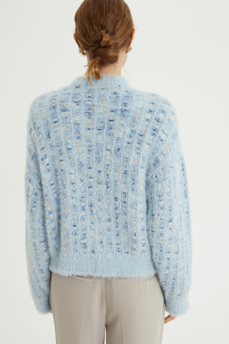 Saco tejido multicolor con textura de pelo y botones perlados en forma de flor. 
