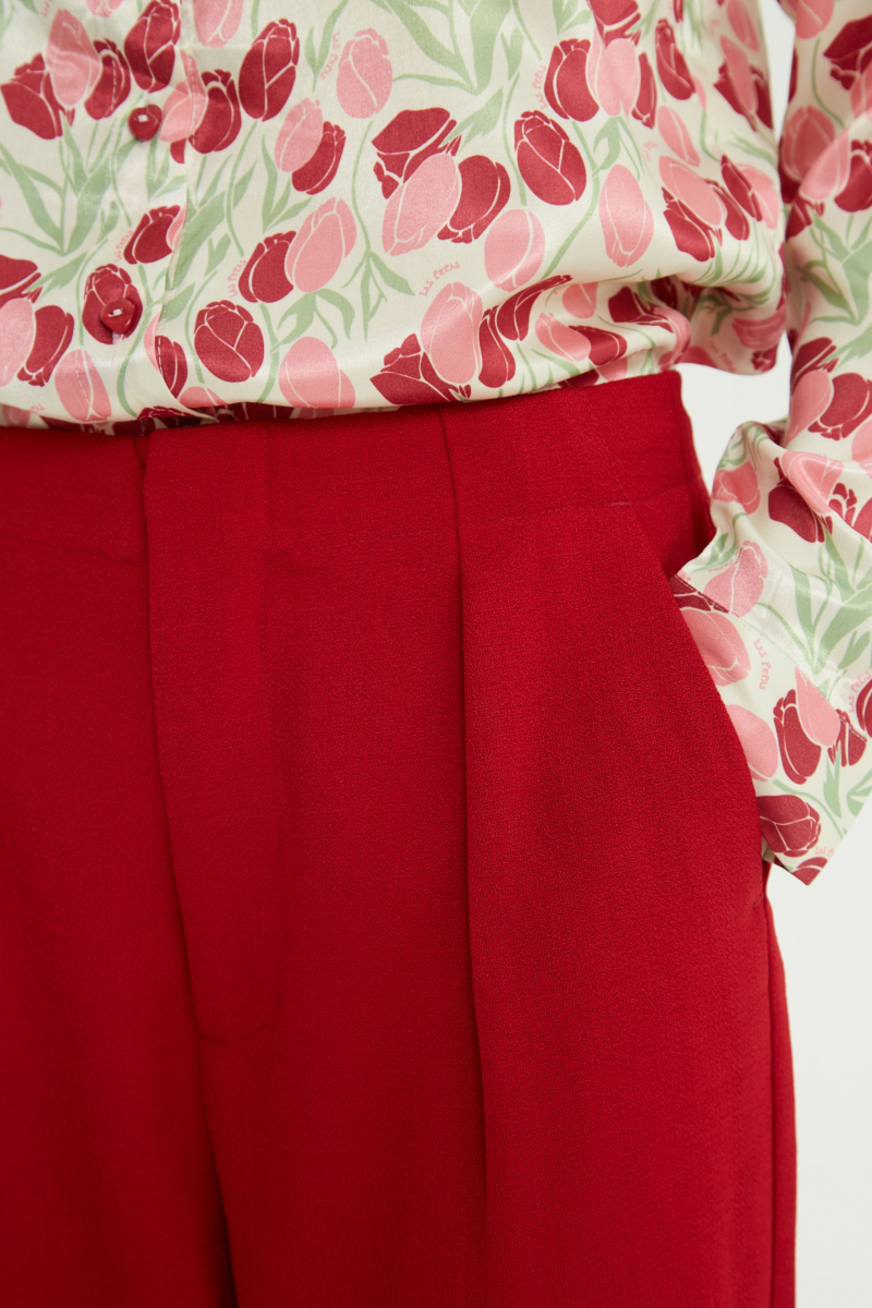 Pantalón rojo sastrero recto tiro medio con terminación ondulada en el ruedo.
