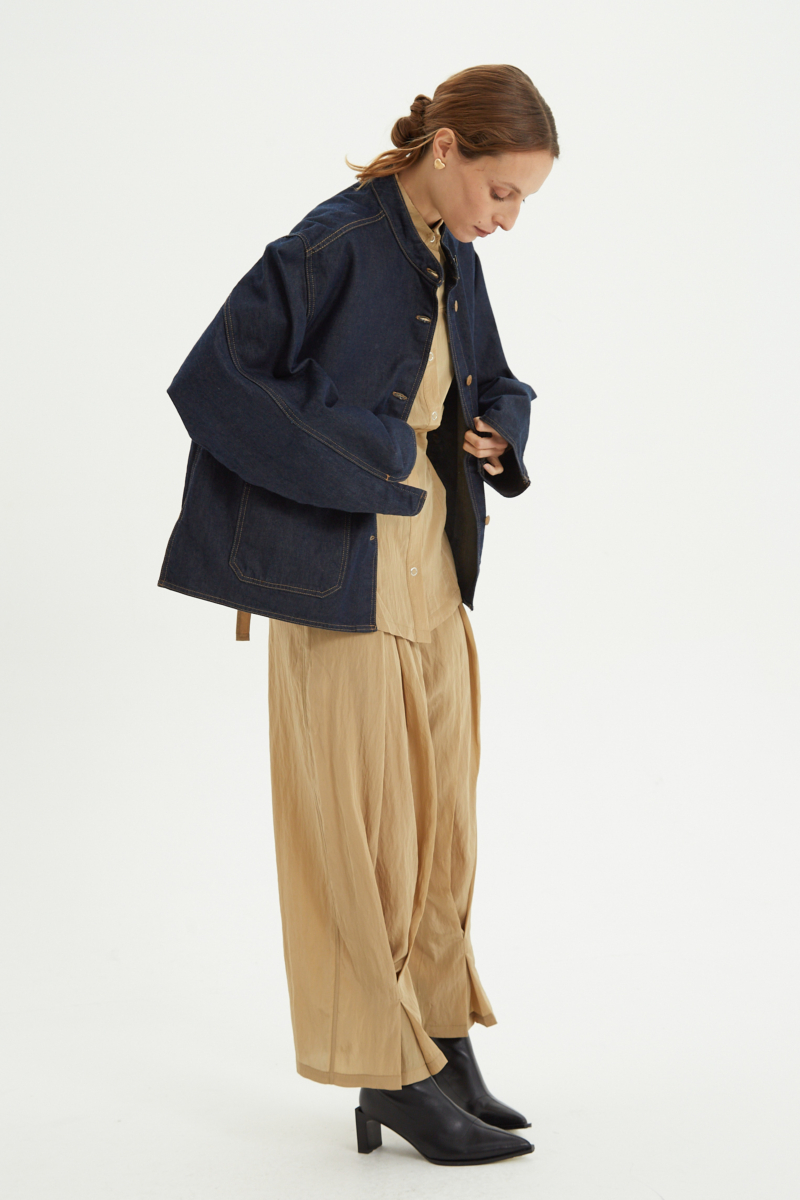 Campera de jean azul oscuro con costuras ocre, oversize, con cuello mao y bolsillos plaque. 
