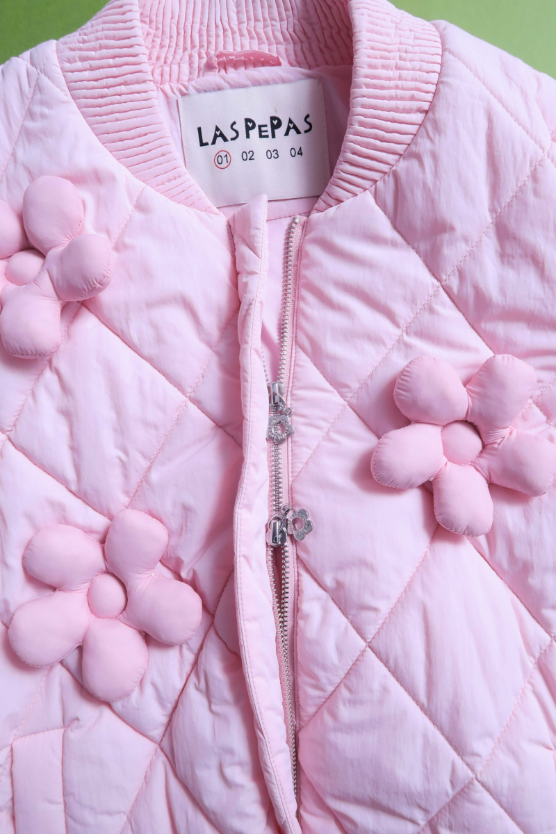 Campera matelaseada con apliques 3D de flores puffer, cuello y puños de ribb, cierre doble camino y mangas desmontables. 