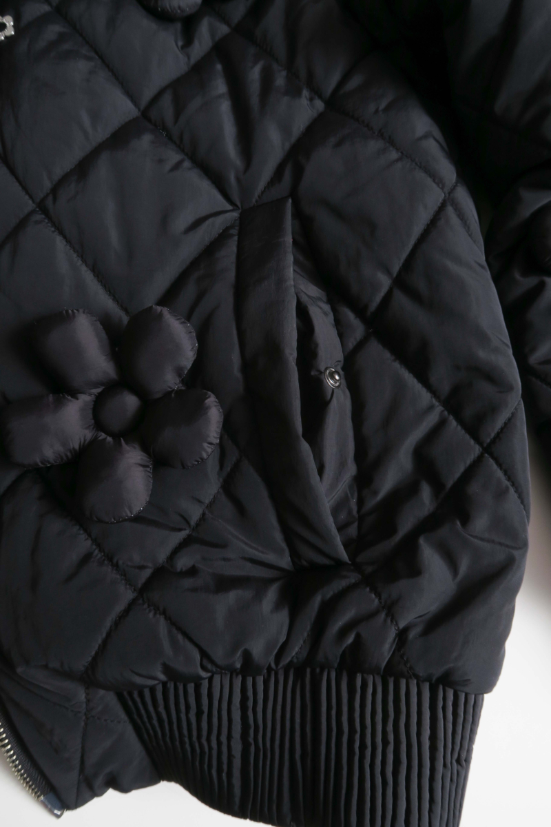 Campera matelaseada con apliques 3D de flores puffer, cuello y puños de ribb, cierre doble camino y mangas desmontables. 