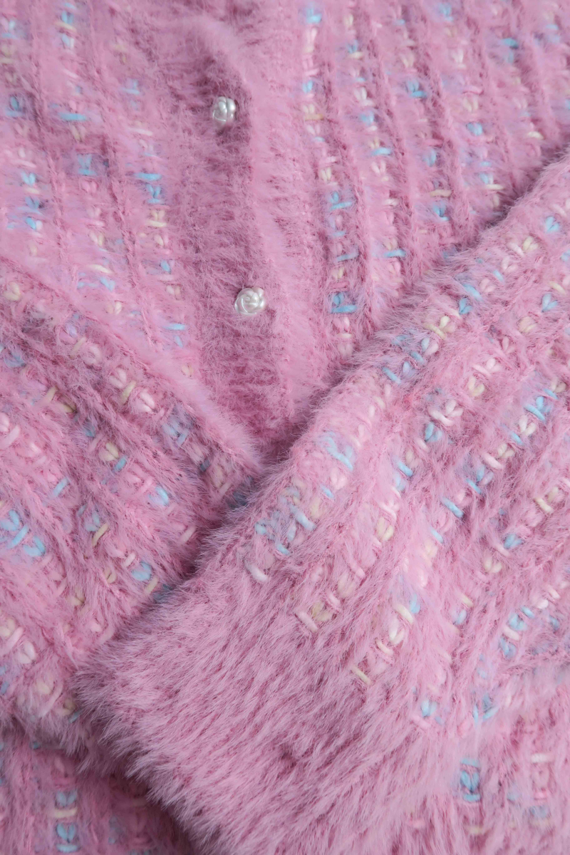 Saco tejido multicolor con textura de pelo y botones perlados en forma de flor. 
