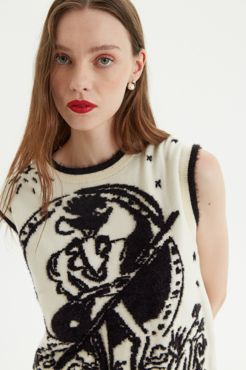Chaleco tejido en jacquard con detalle de pelo en tejido, cuello, sisas y ruedo. 
