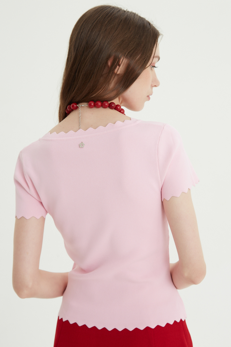 Remera rosa tejida  con terminación ondulada en mangas, ruedo y escote, de escote cuadrado y corte recto larga a la cadera. 