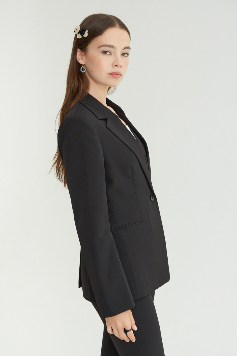 Blazer negro sastrero recto con hombreras, bolsillos ojal y pinzas en frente y espalda. 
