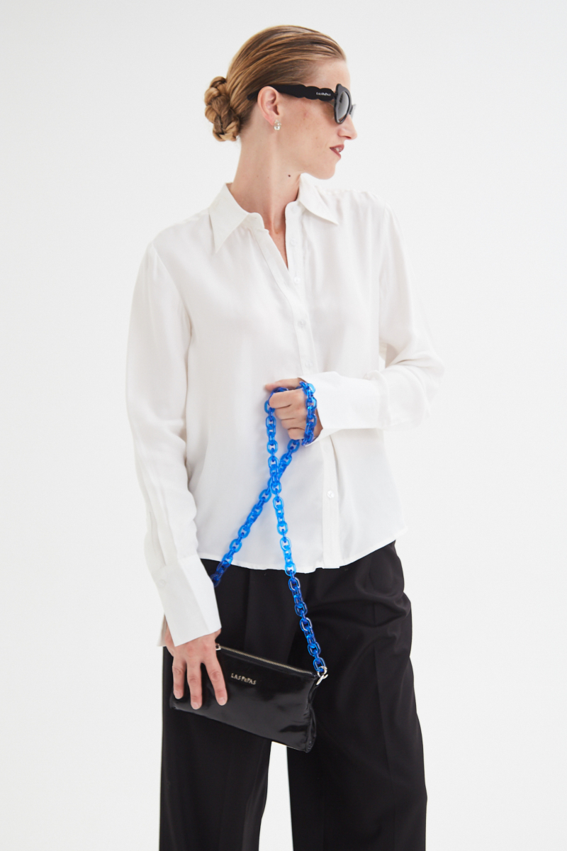 Camisa blanca de calce recto y puños anchos con textura suave de piel de durazno. 
