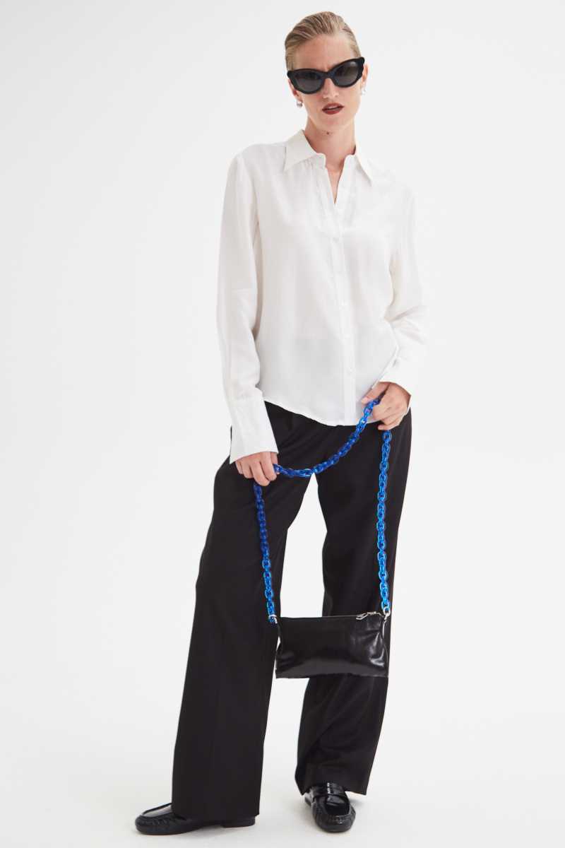 Camisa blanca de calce recto y puños anchos con textura suave de piel de durazno. 
