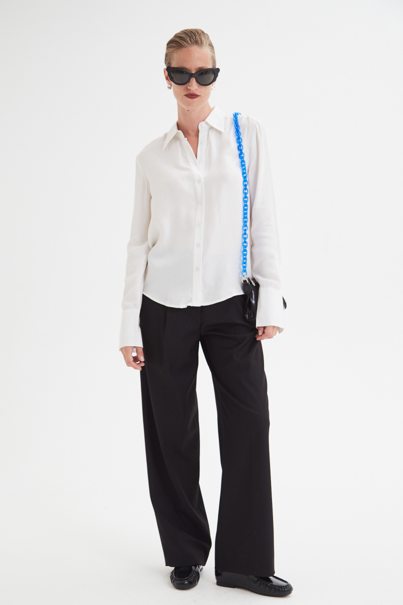 Camisa blanca de calce recto y puños anchos con textura suave de piel de durazno. 
