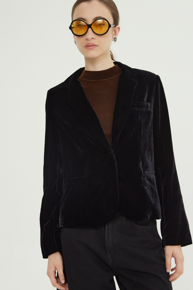 Blazer negro sastrero con hombreras de corte recto con pinzas de entalle y largo hasta la cadera.