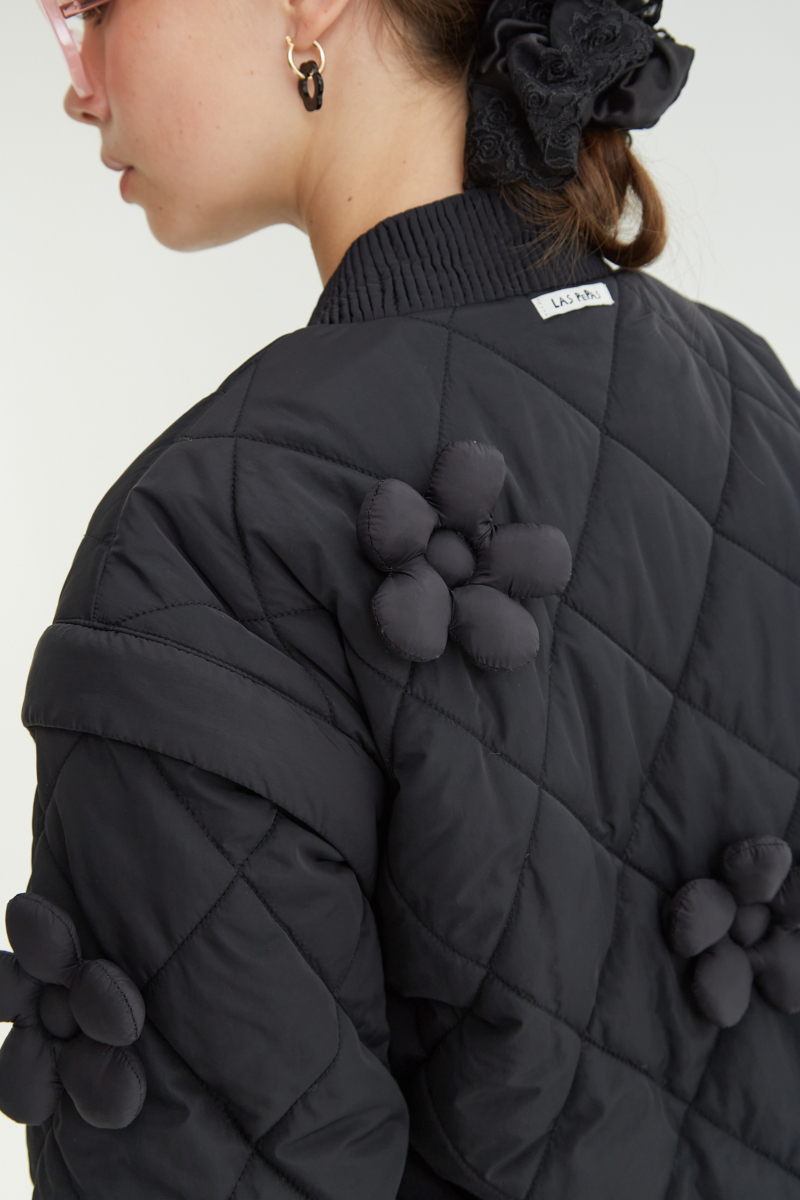 Campera matelaseada con apliques 3D de flores puffer, cuello y puños de ribb, cierre doble camino y mangas desmontables. 