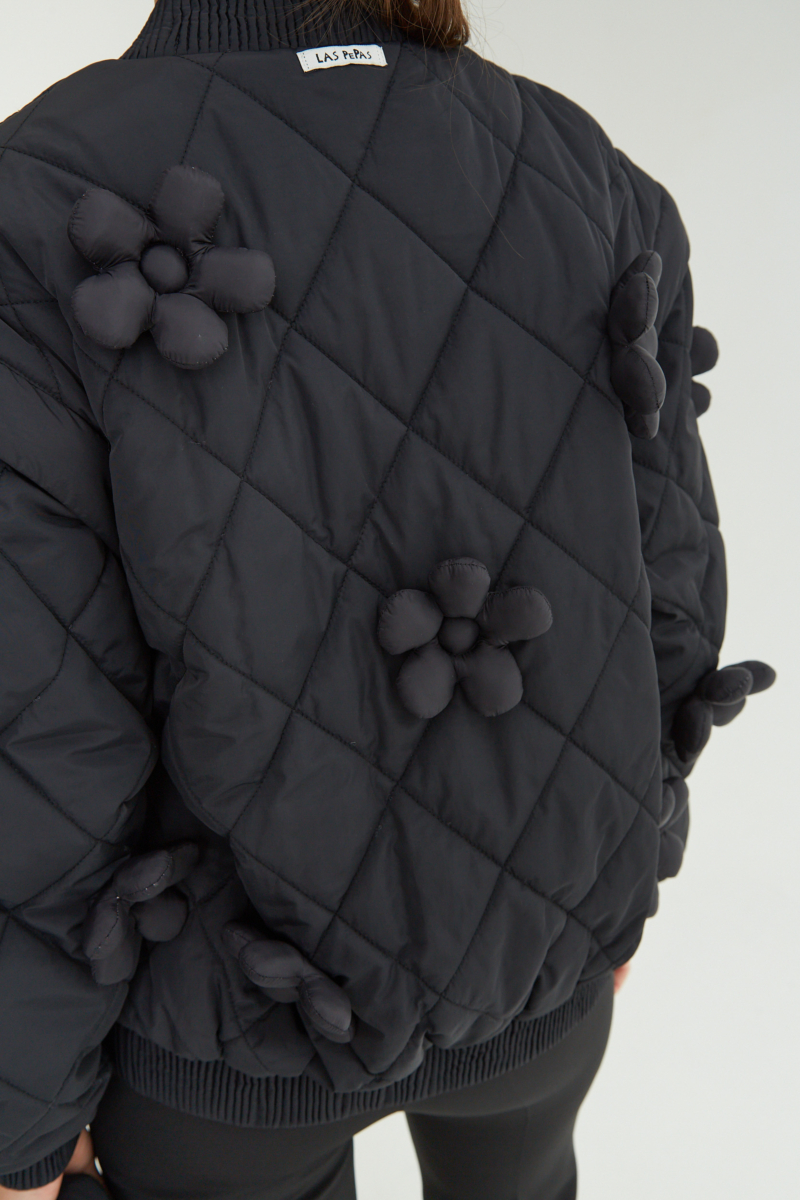 Campera matelaseada con apliques 3D de flores puffer, cuello y puños de ribb, cierre doble camino y mangas desmontables. 