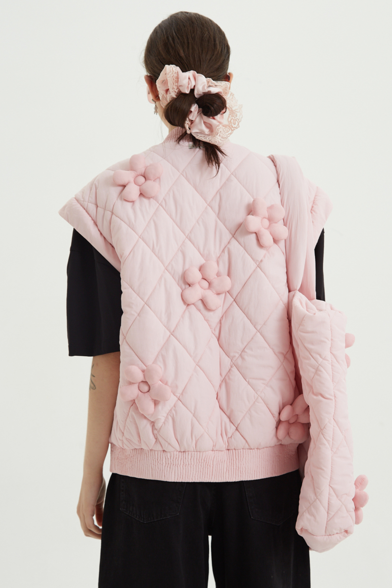 Campera matelaseada con apliques 3D de flores puffer, cuello y puños de ribb, cierre doble camino y mangas desmontables. 