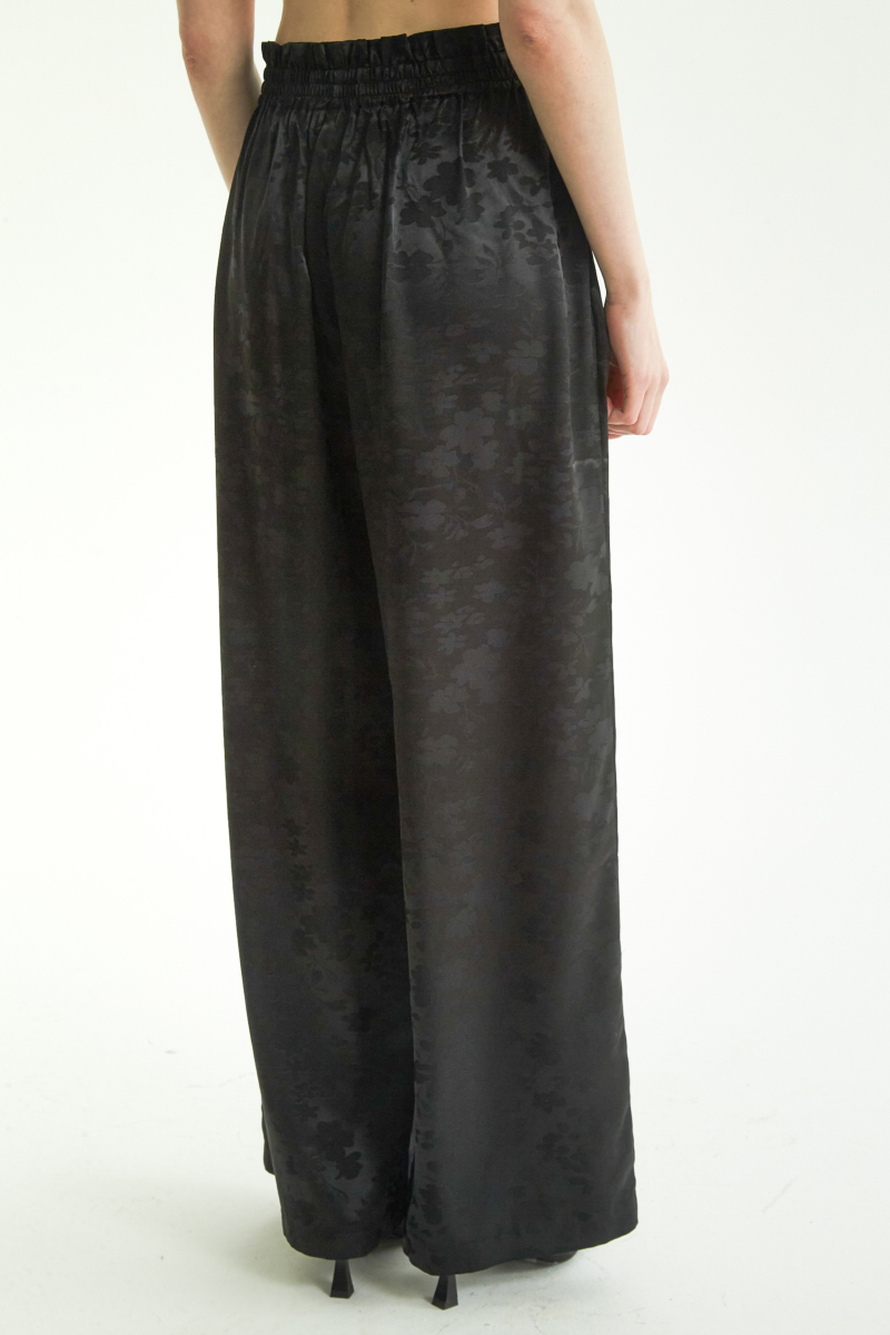 Pantalón negro amplio tiro alto satinado de jacquard con motivo floral y cintura elastizada con pliegues.