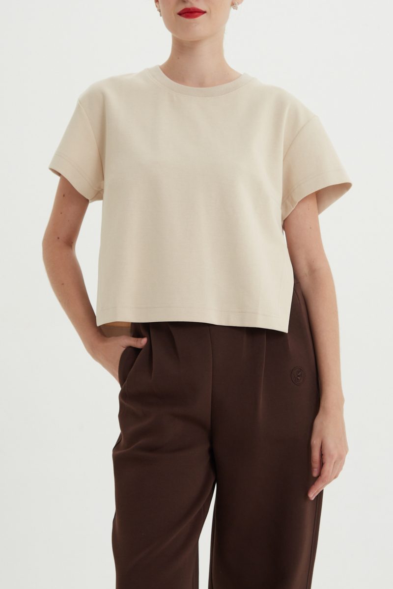 Remera beige crop de algodón recta, de mangas cortas y cuello redondo. 