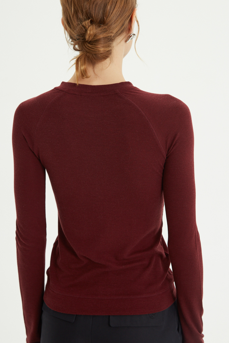 Remera bordo manga larga raglán de corte recto y larga a la cadera con cuello redondo y ruedo ancho. 
