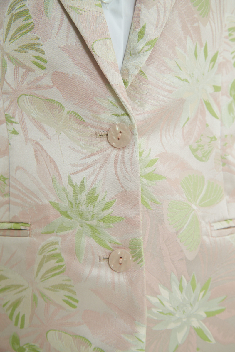 Saco rosa sastrero recto de jacquard satinado con hombreras, solapa con cruce recto y botones tornasolados. 
