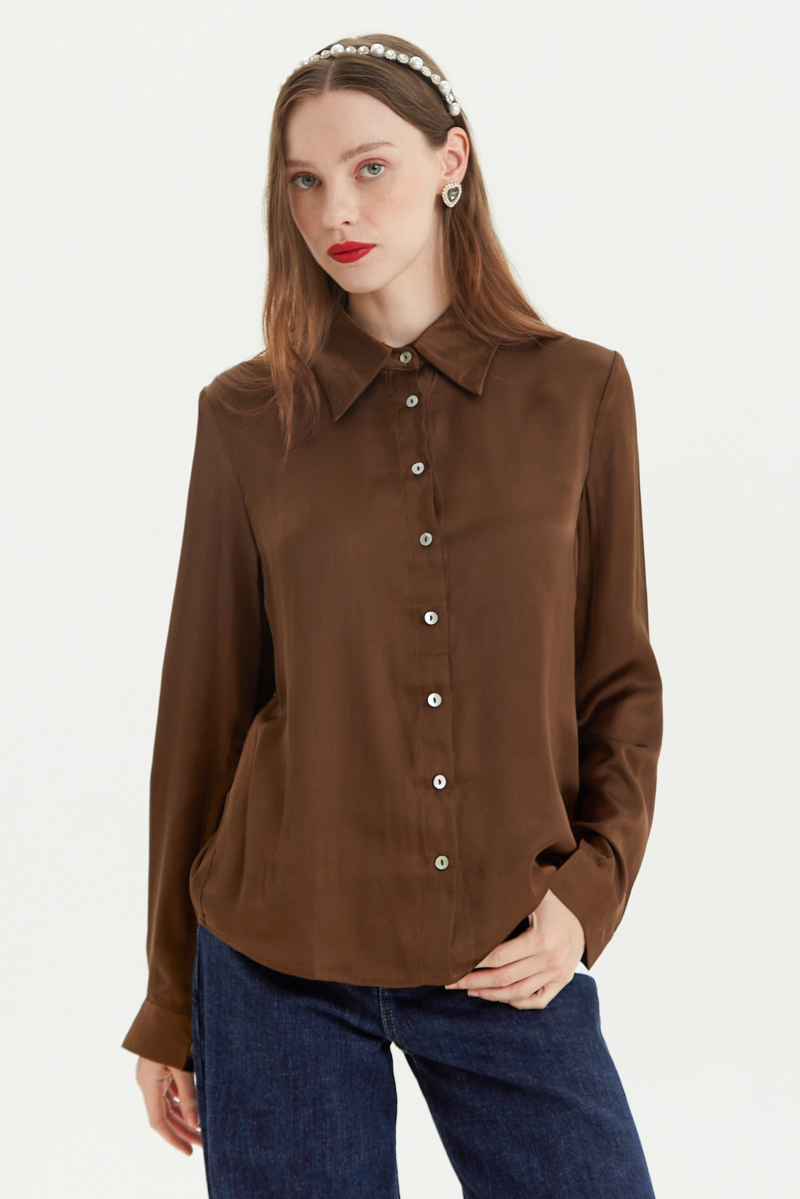 Camisa satinada con botones nacarados a contratono, de corte recto y larga hasta la cadera. 