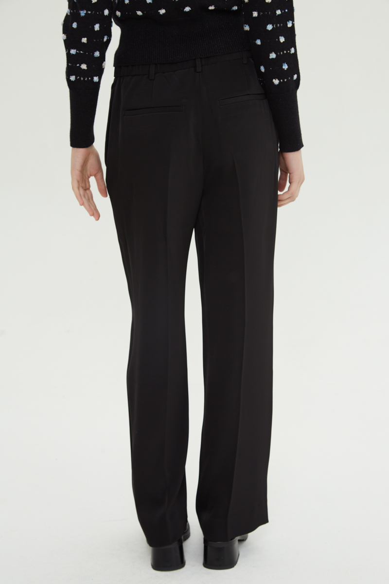 Pantalón negro sastrero tiro alto recto y largo a los tobillos con cintura con elástico y lazo a tono para atar. 