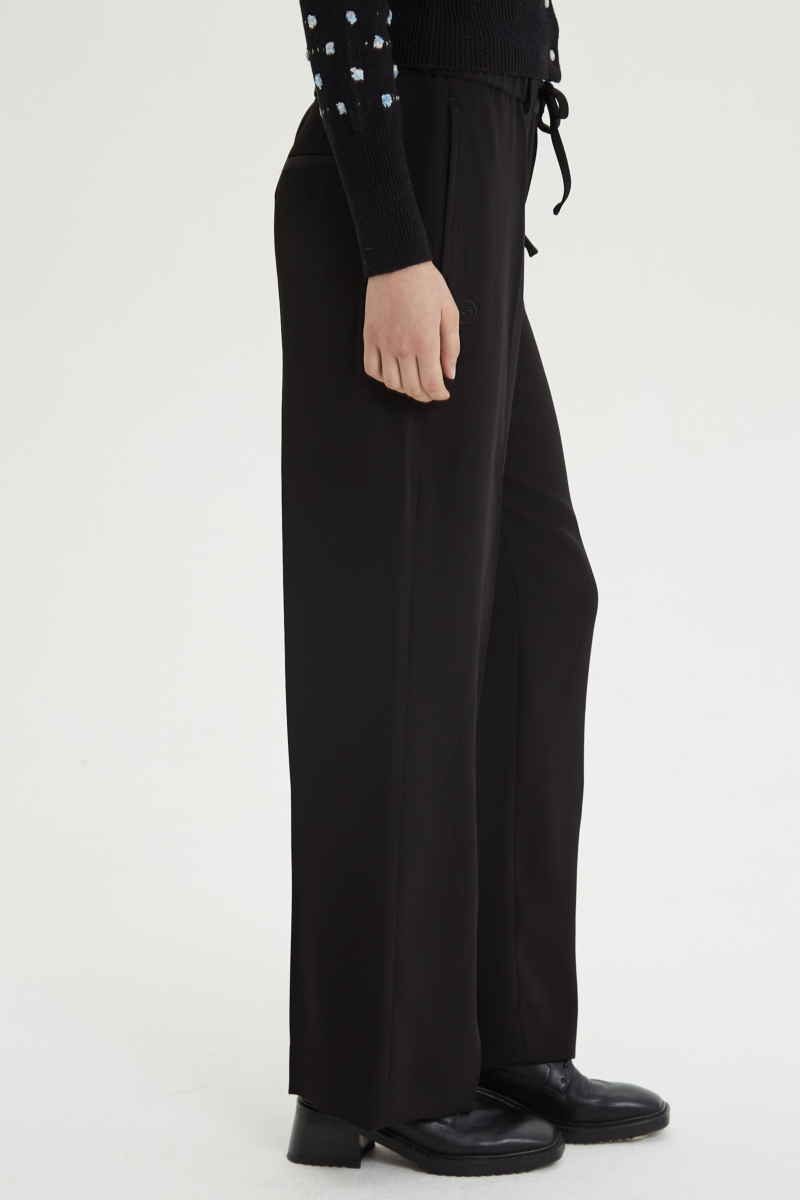 Pantalón negro sastrero tiro alto recto y largo a los tobillos con cintura con elástico y lazo a tono para atar. 