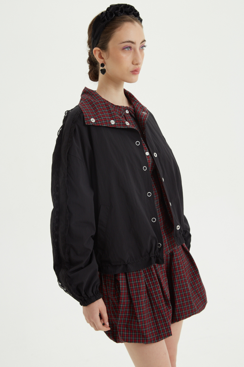 Campera reversible con puntilla y motivo de cuadros, cuello alto, broches snap y cintura con tancas. 
