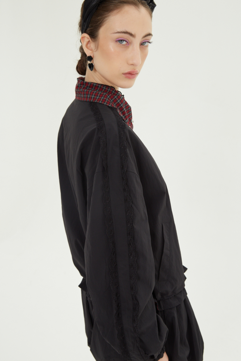 Campera reversible con puntilla y motivo de cuadros, cuello alto, broches snap y cintura con tancas. 
