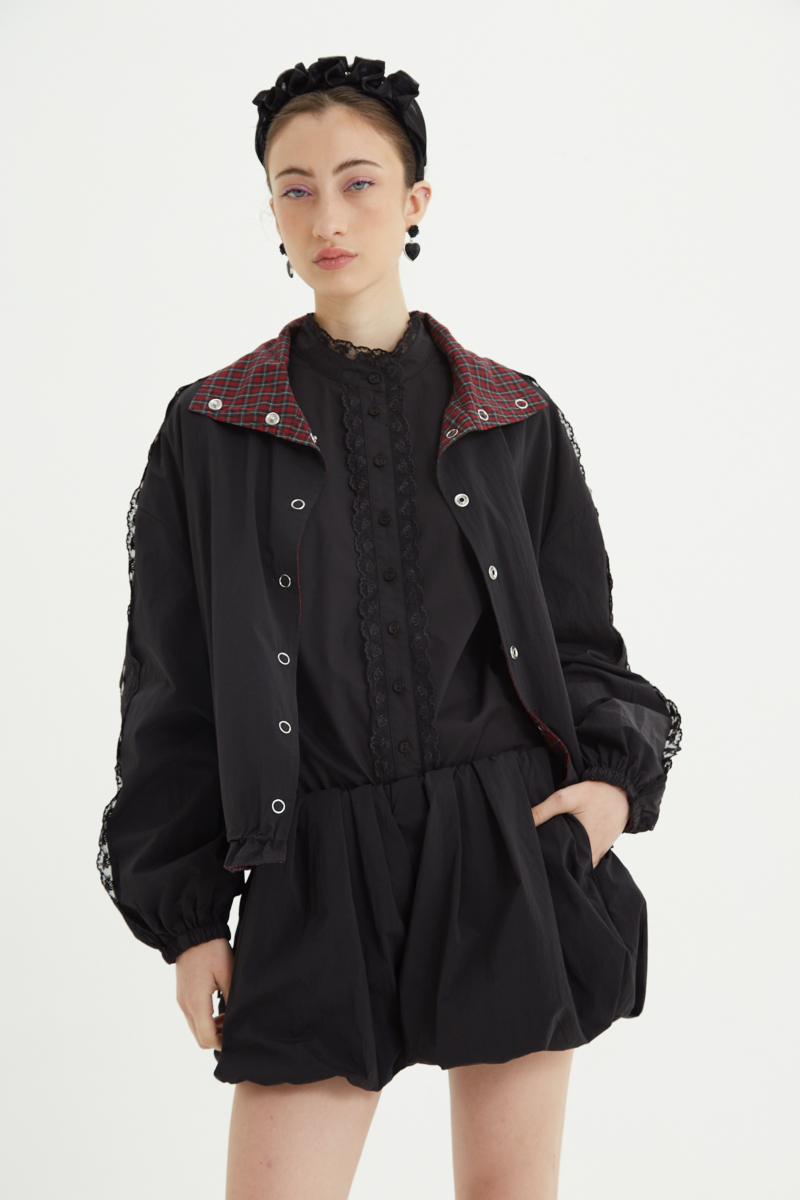 Campera reversible con puntilla y motivo de cuadros, cuello alto, broches snap y cintura con tancas. 

